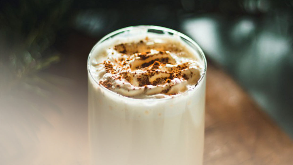 Cremiger Smoothie mit Kombucha Tannenzweige Holztisch